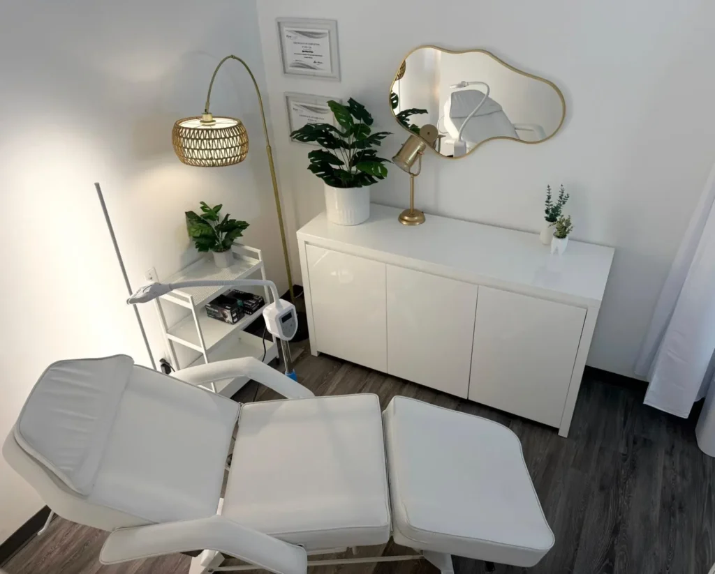 Professional teeth whitening studio in Peterborough with a modern, clean aesthetic, featuring a comfortable white treatment chair, gold accents, and lush green plants. Ideal for a relaxing and effective teeth whitening experience.